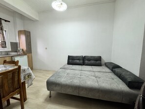 Una stanza piccola e funzionale, con un letto, un tavolo e angolo cottura.