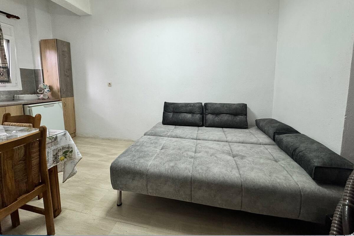 Una stanza piccola e funzionale, con un letto, una scrivania e angolo cottura.