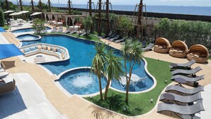 Una piscina al aire libre, cabañas de piscina (de pago)