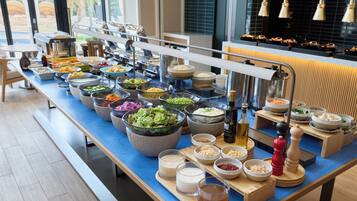 A buffet setup with various food items and condiments.