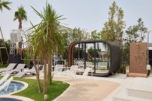 Una piscina al aire libre, camas de piscina con cargo