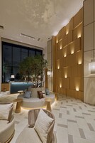 A modern interior with a seating area, a large window, and a wall with illuminated panels.