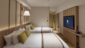 Habitación de hotel con dos camas, televisor y panel de pared de madera.