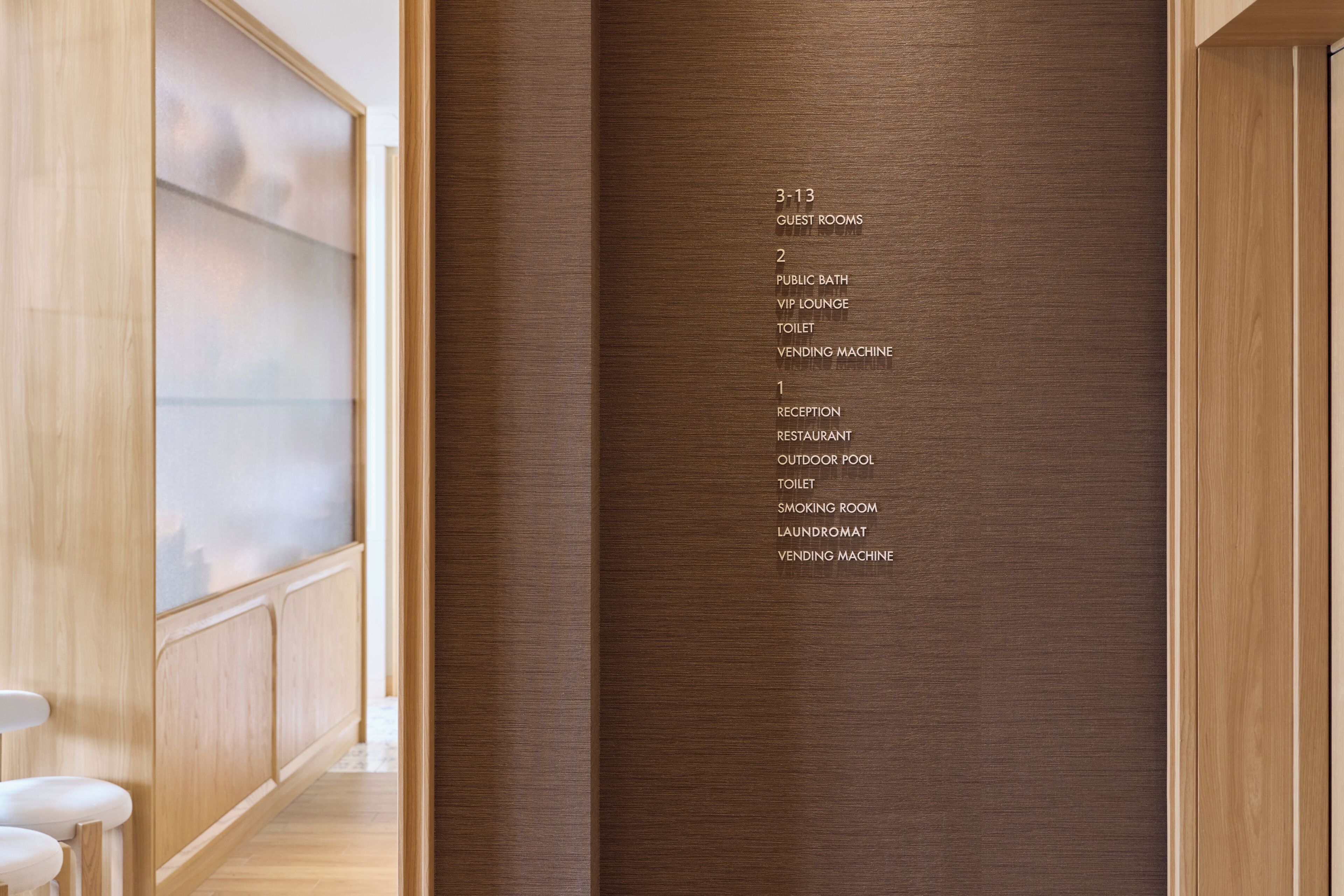 A hotel interior with a directory listing guest rooms, public bath, VIP lounge, toilet, vending machine, reception, restaurant, outdoor pool, smoking room, and laundromat.