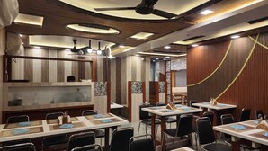 Un restaurant doté de nombreuses tables, de chaises et d’un plafond au design moderne.