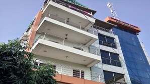 Un immeuble à plusieurs étages portant une enseigne indiquant « Oracle Guest House ».