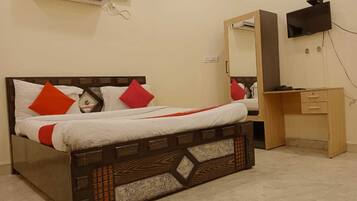 Quarto com cama, escrivaninha de madeira, espelho e ar condicionado.