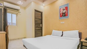 A hotel room with a bed, a door, a window, and a poster on the wall. - Raj Residency Govindpuri (New Delhi)