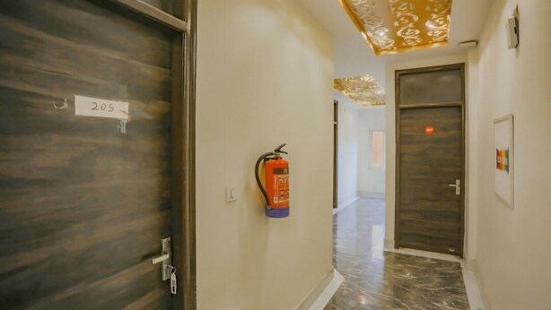 A hallway with a fire extinguisher, a door labeled '205', and a patterned ceiling. - Raj Residency Govindpuri (New Delhi)