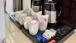 A kitchenette with a coffee maker, mugs, and a kettle. - HOTEL LA SERA (Srinagar)