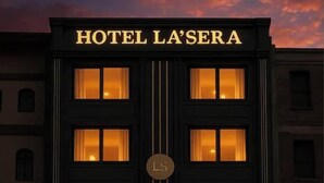 A building with the sign 'HOTEL LA'SERA' and multiple illuminated windows. - HOTEL LA SERA (Srinagar)