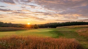 A golf course with a flag at the tee, surrounded by grass and trees. - Roxburghe Cottages, Part of Destination by Hyatt (Kelso)