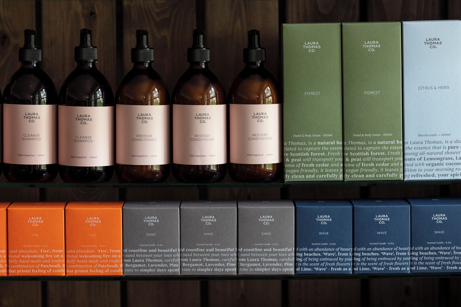 A variety of Laura Thomas Co. products including shampoos, conditioners, and scented candles.