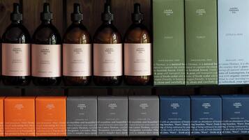 A variety of Laura Thomas Co. products including shampoos, conditioners, and scented candles.
