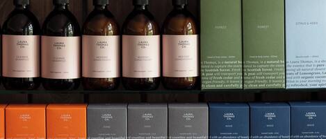 Variedad de productos de Laura Thomas Co., incluyendo champús, acondicionadores y velas perfumadas.