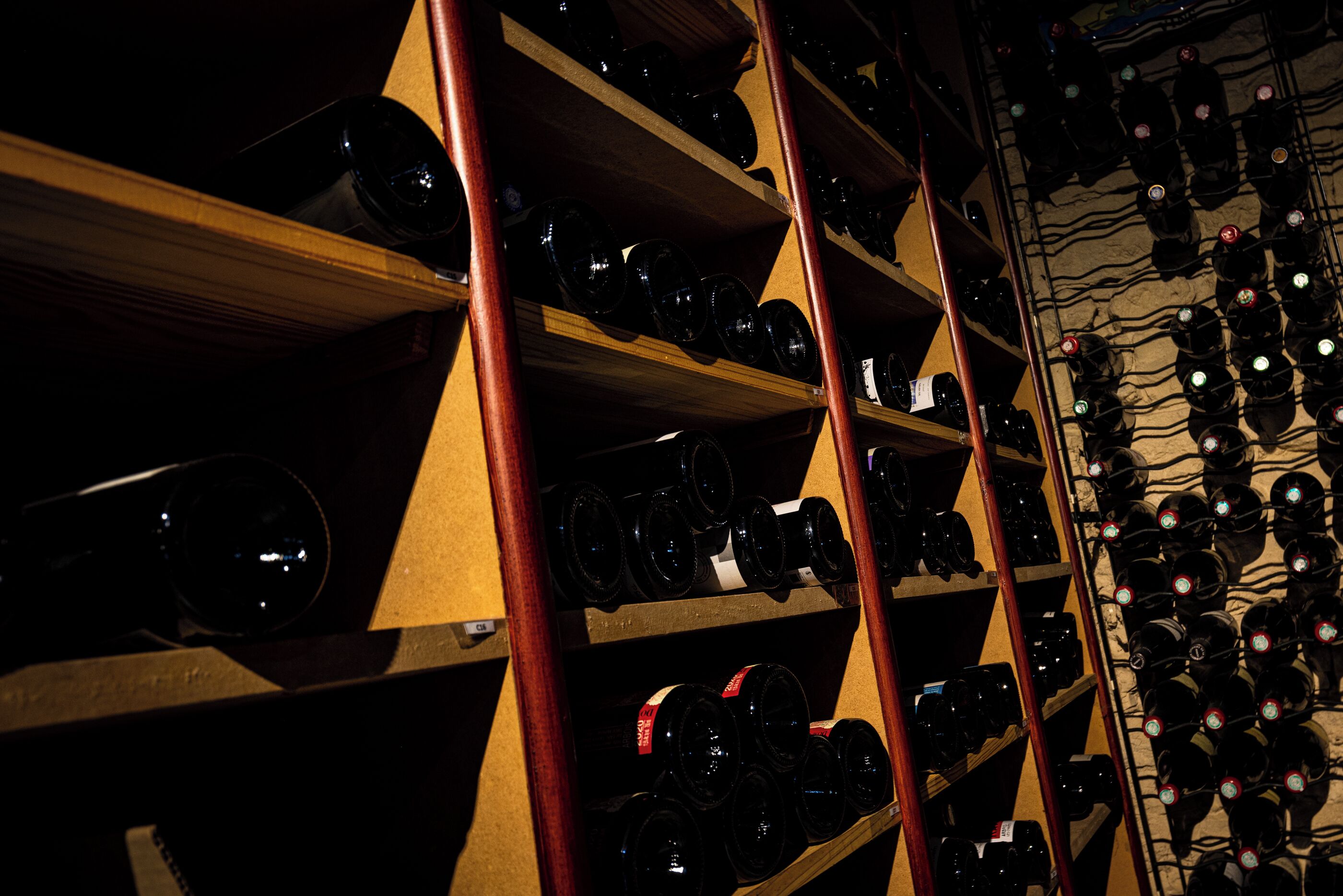 Uma adega com várias prateleiras cheias de garrafas de vinho.
