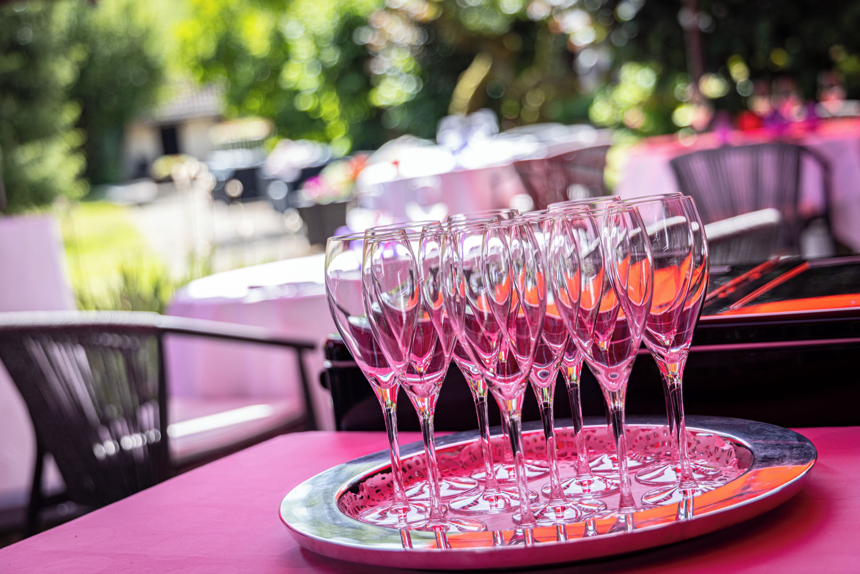 A table with a tray of empty wine glasses.