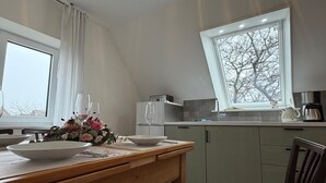 Una cucina moderna con zona pranzo, un'ampia finestra e vista sugli alberi.