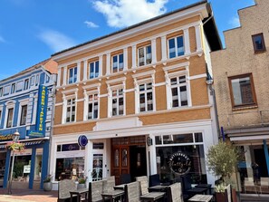Ein Gebäude mit Schaufenster, Außenbereich und Hinweisschild für ein Restaurant.