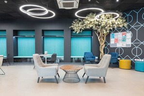 A modern lounge area with seating, a coffee table, and a bulletin board. - Student Only Onyx (Birmingham)