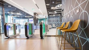 A modern lobby with a reception desk, a self-service kiosk, and a seating area with chairs. - Student Only Onyx (Birmingham)