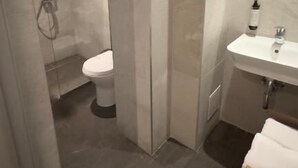 A modern bathroom with a shower, toilet, and sink. - Villa Piazzetta (Bacău)