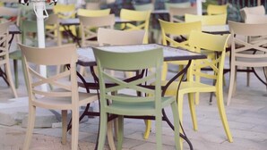 A row of outdoor tables and chairs with a tiled floor. - Villa Piazzetta (Bacău)