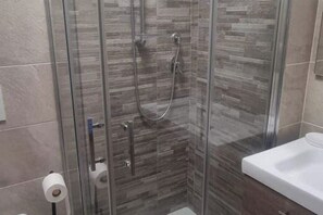 Een douche, een haardroger, een bidet, handdoeken