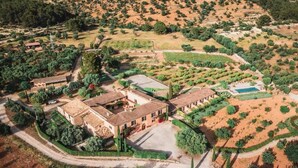 An aerial view of a property with multiple buildings, a swimming pool, and landscaped gardens. - Finca Es Cabàs (Santa Maria del Camí)