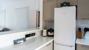 A modern kitchen with a Bosch refrigerator, a first aid kit, a blender, and a coffee maker. - Special Launch Price! Amazing Sea View 1BR Villa, Garden & Gym (Polis Chrysochous)
