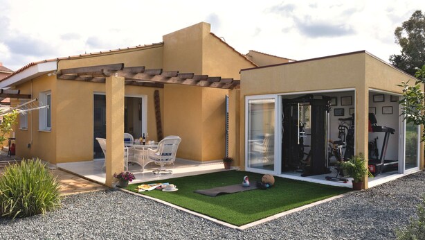 A house with a patio, outdoor seating, a small garden, and exercise equipment. - Special Launch Price! Amazing Sea View 1BR Villa, Garden & Gym (Polis Chrysochous)