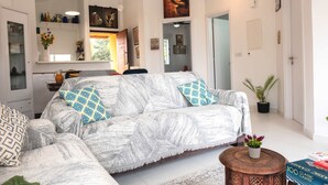 A living room with a sofa, a coffee table, and a bookshelf. - Special Launch Price! Amazing Sea View 1BR Villa, Garden & Gym (Polis Chrysochous)