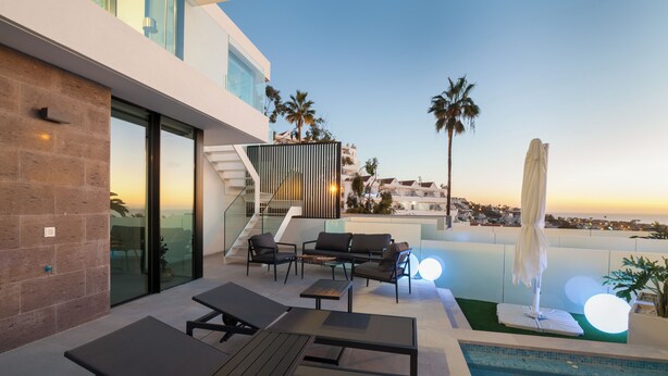 A modern outdoor pool area with lounge chairs, a table, and a staircase leading to an upper level. - 200m NEW A Villa with private, heated pool and amazing ocean view (Costa Adeje)