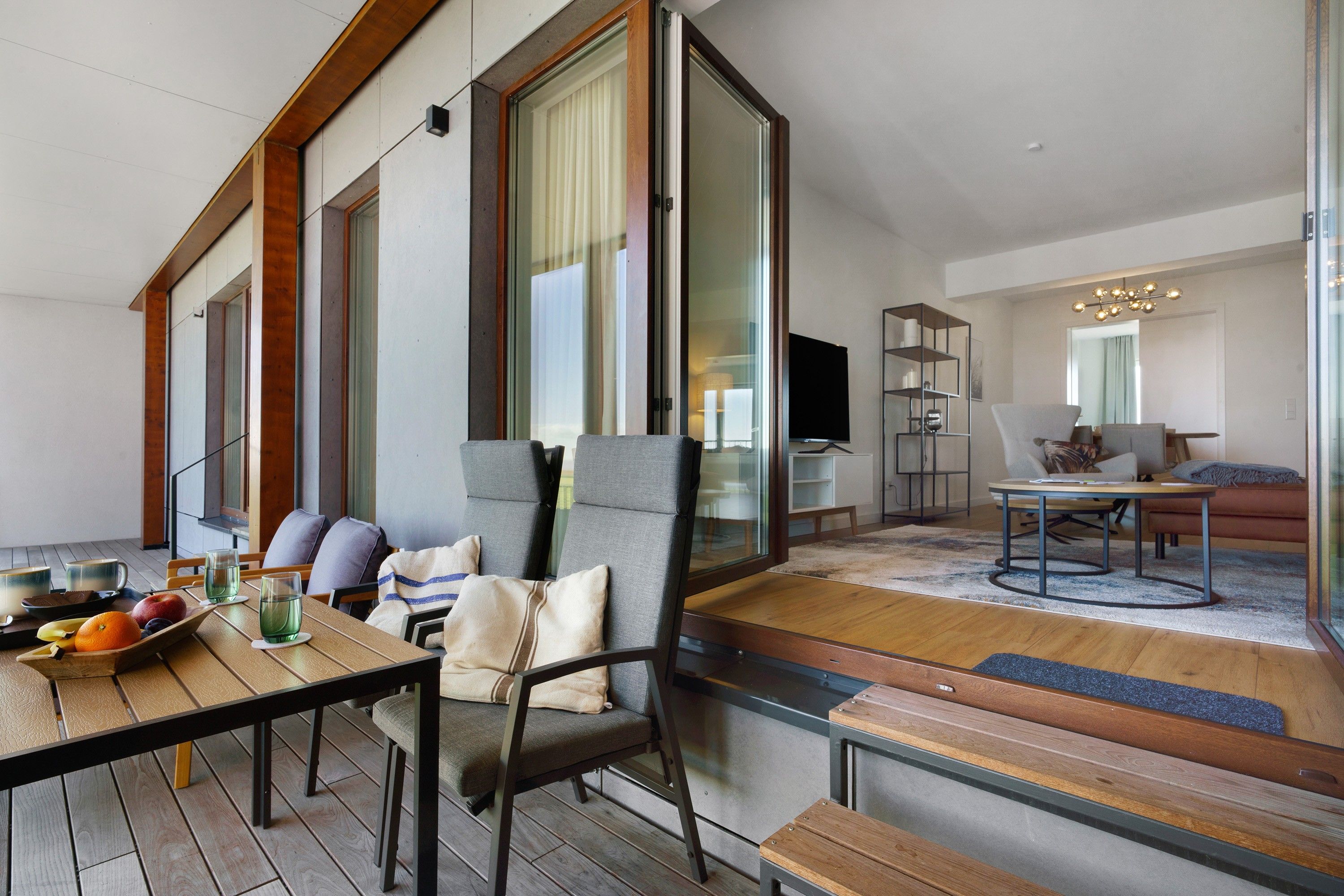 Una sala de estar moderna con una mesa de comedor de madera, asientos cómodos y un televisor.