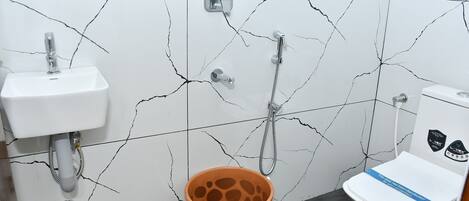 A bathroom with a white sink, a toilet, and a shower.