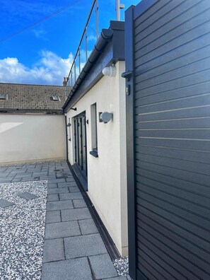 A modern building with a flat roof, a garage door, and a paved walkway. - 5 Bed House/sleeps10/free Parking/pets/city Centre (Edinburgh)