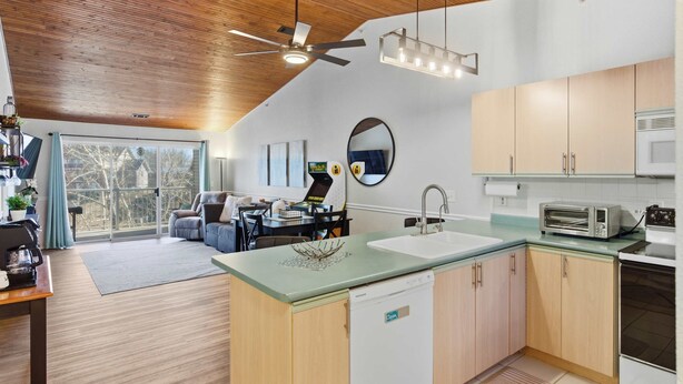 Una cocina moderna con lavavajillas, microondas y comedor con mesa y sillas.
