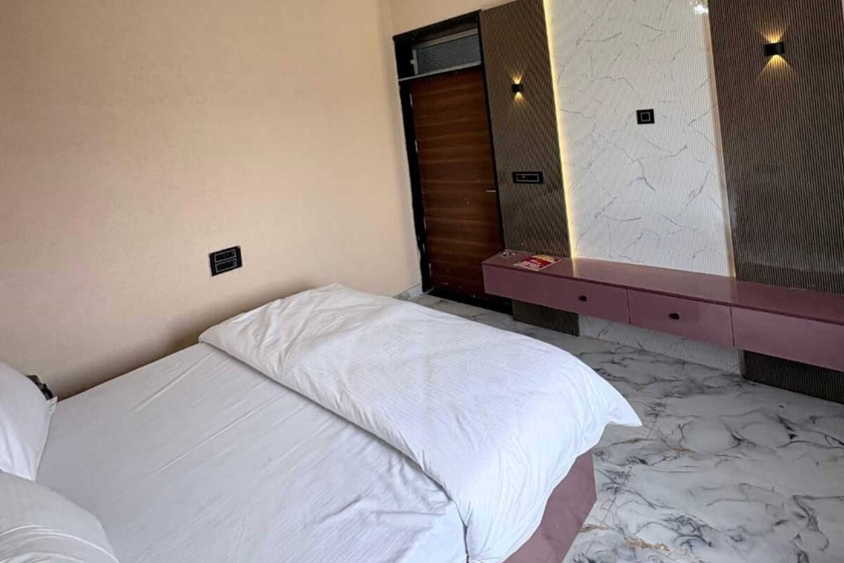 Un dormitorio con cama, ventilador de techo, espejo y piso con diseño de mármol.