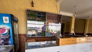 Un'area reception con un banco, un frigo per Pepsi e una teca in vetro.