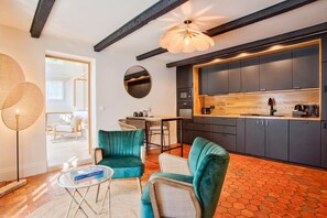 Une cuisine moderne avec des meubles de couleur sombre, un plan de travail en bois et un luminaire suspendu.