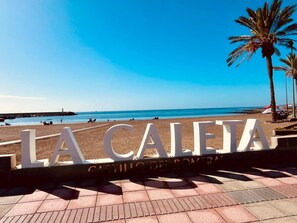 Eine Strandansicht mit dem Schild 'LA CALETA' und 'CASTILLO DEL ROMER', das den Ort angibt.