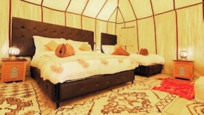 Une chambre avec un lit, des tables de chevet et un tapis à motifs.