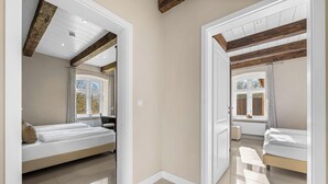 Une chambre à coucher avec un lit, une fenêtre et une poutre en bois au plafond.
