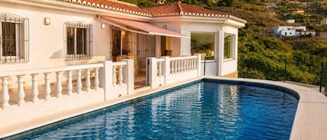 A swimming pool with a white building in the background.