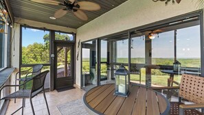 A covered outdoor area with a ceiling fan, a wooden deck, and a view of the landscape. - Sunset Ridge Private Patio (Lake Ozark)