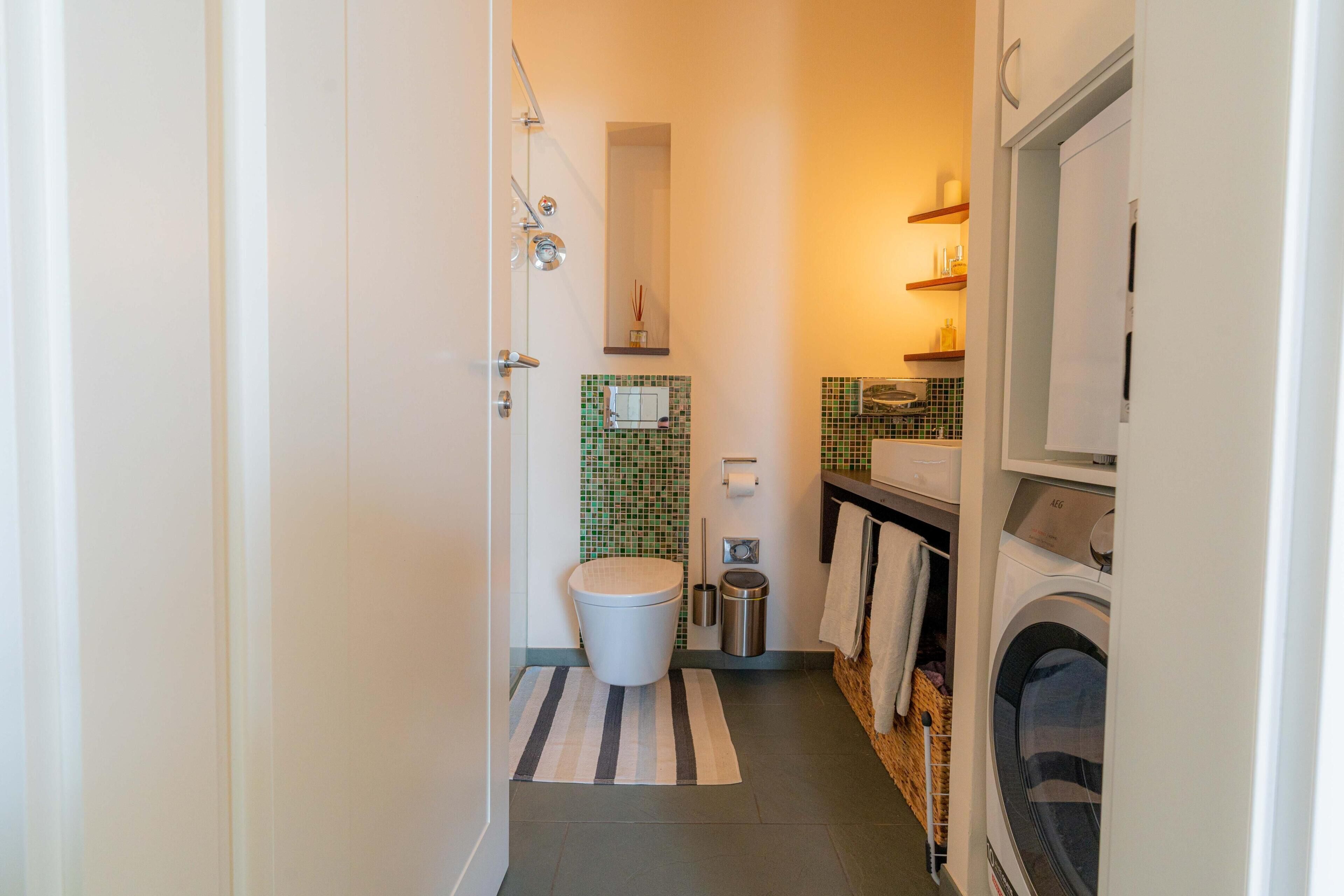 Une petite salle de bain comprenant des toilettes, un bidet et un lave-linge.