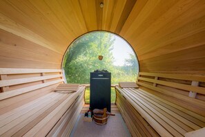A sauna with wooden benches and a view of greenery outside. - Mühlendeich Vacation Apartment with Sauna and Garden in Vollerwiek (Vollerwiek)