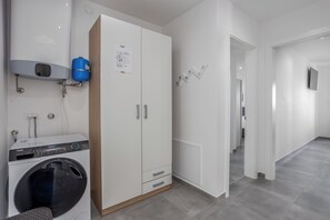 A modern apartment with a washer-dryer unit, a water heater, and a large wardrobe. - Dramalj luxury villa - pool, whirlpool & sea view (Dramalj)