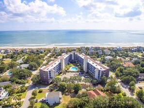 A coastal hotel with a central courtyard, multiple floors, and a view of the beach. - Litchfield Retreat 613 - North Litchfield, Balcony, Ocean View (Pawleys Island)