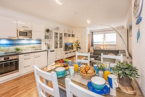 A modern kitchen with white cabinetry, a built-in oven, and a microwave. - Cozy vacation apartment Edda - close to the beach in the heart of Zinnowitz (Zinnowitz)
